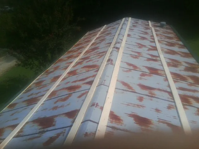 Rusted metal roof panels with new wood purlins before replacement — Storm Damage Roof Repair in Londonderry by Roofing Brothers